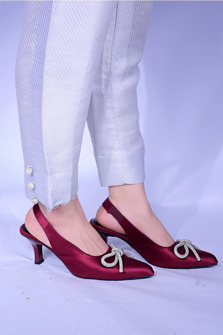 Maroon fancy heels with a shiny bow.