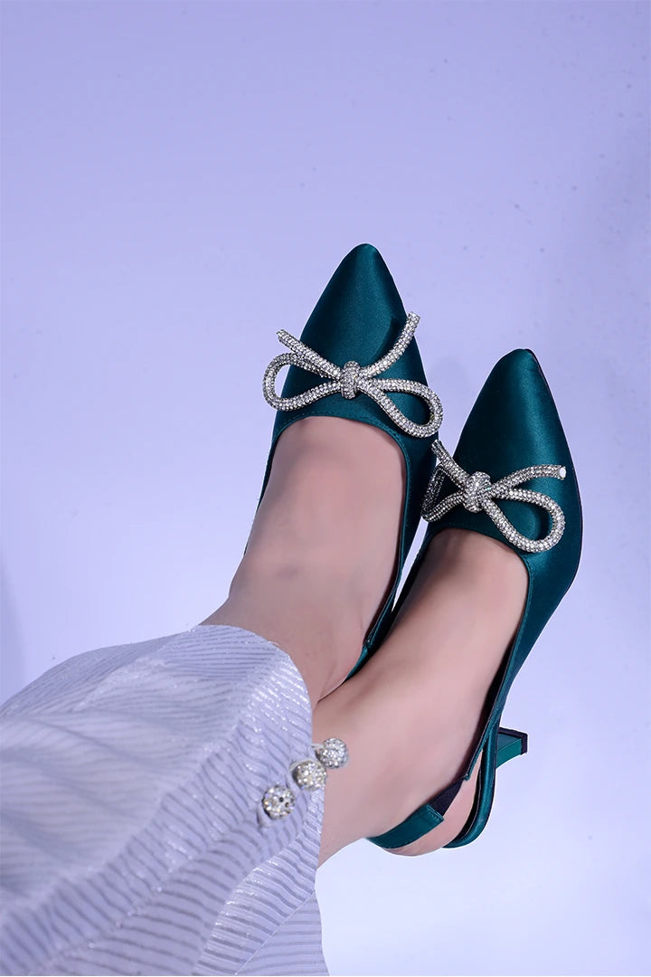 Green fancy heels with a shiny bow.