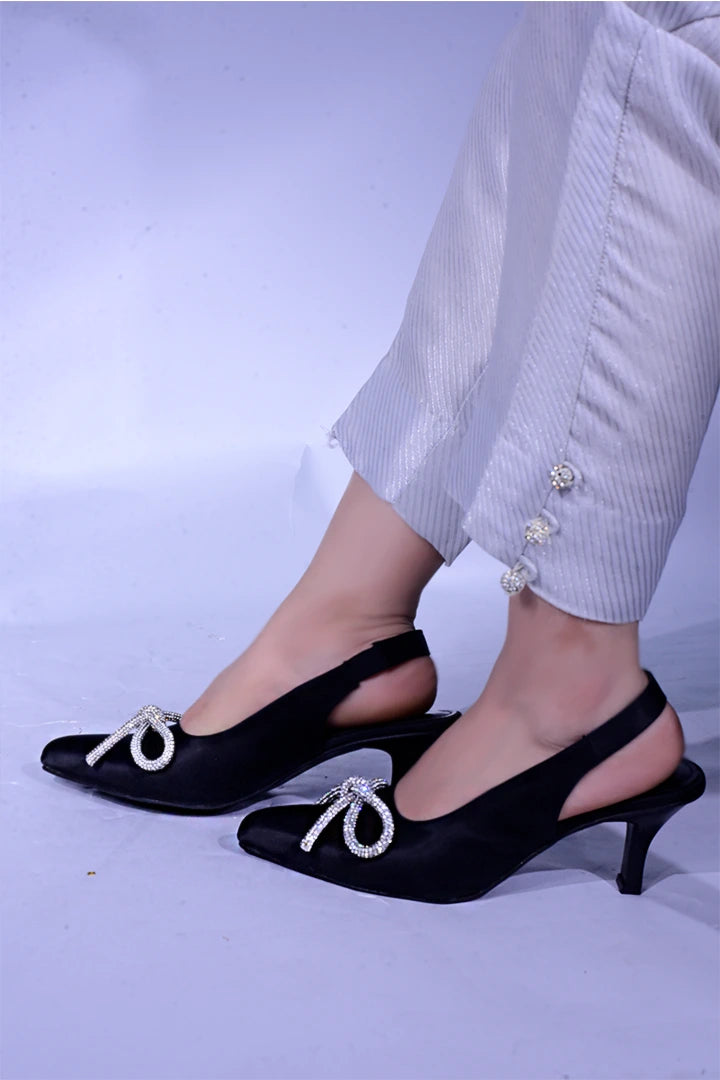 Black fancy heels with a shiny bow.